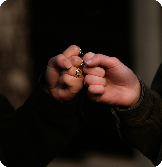 Two people linking pinky fingers in a gesture of trust